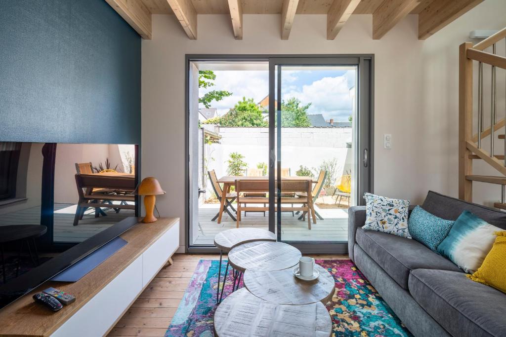 a living room with a couch and a table at Ernestine by Cocoonr in Rennes