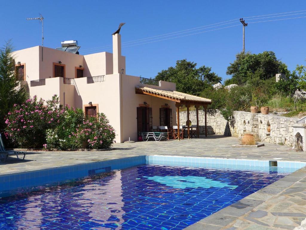 a house with a swimming pool in front of a house at Charming Villa in Axos Crete with Swimming Pool in Axós