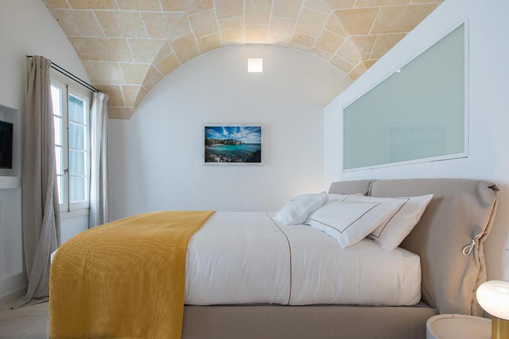 a bedroom with a bed with a yellow blanket on it at Samarés in Ciutadella