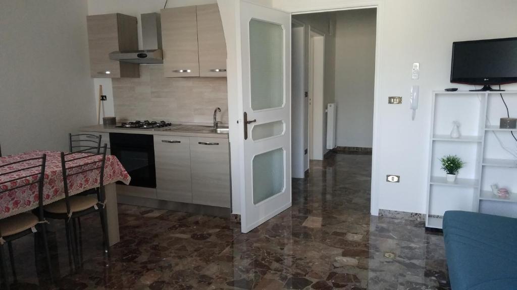 a kitchen with a sink and a table and a door at Casa Vacanze Leo 2 in Acquarica del Capo