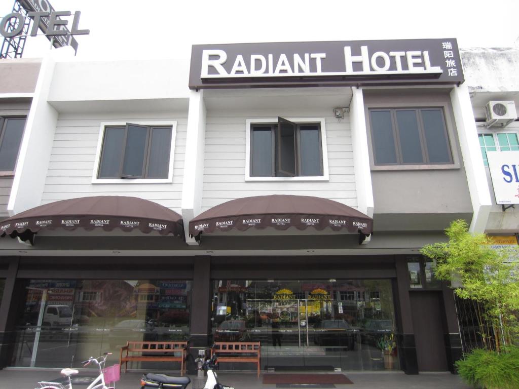 a white building with a restaurant at Radiant Hotel in Sitiawan