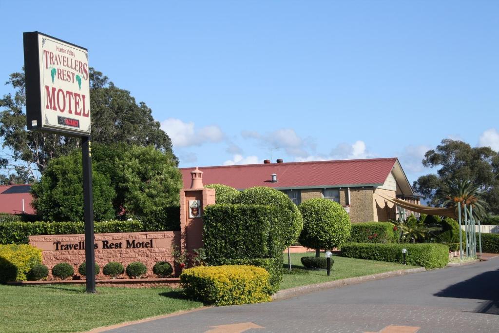 a red brick building with a sign on the side of it at Hunter Valley Travellers Rest Motel in Cessnock