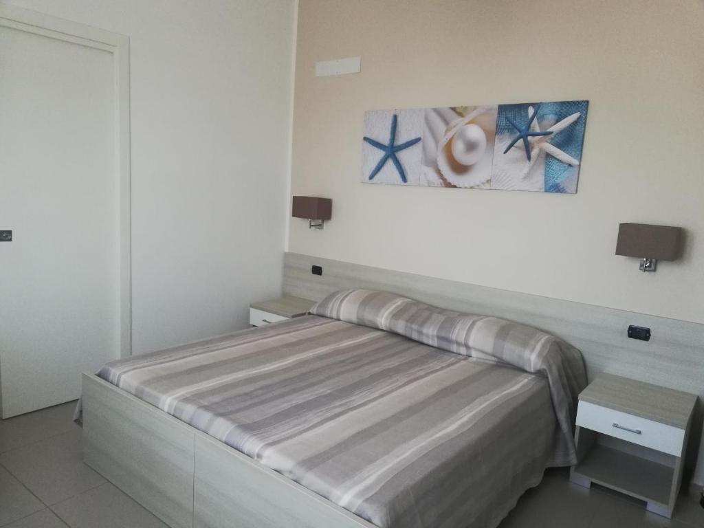 - une chambre avec un lit et une peinture murale dans l'établissement Stella marina, à Palinuro