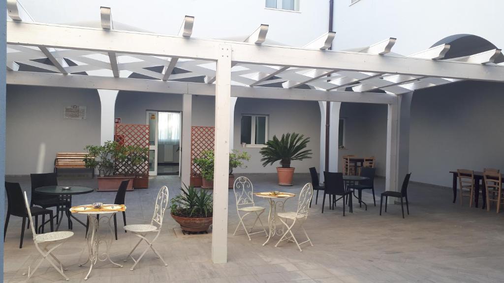 a patio with tables and chairs in a building at Chiostro Delle Cererie in Matera