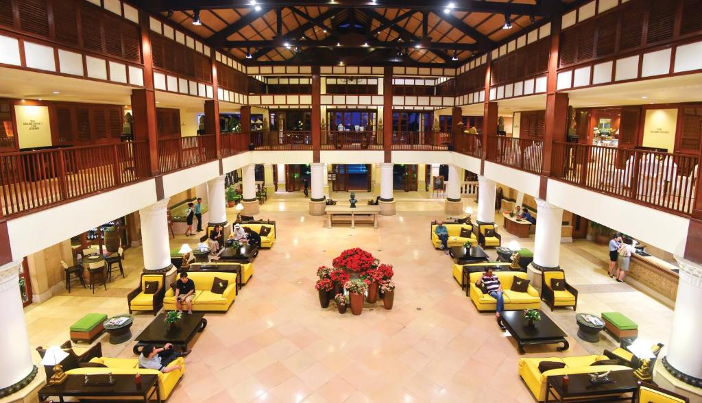 The open lobby has a large central seating area beneath a high timber roof.