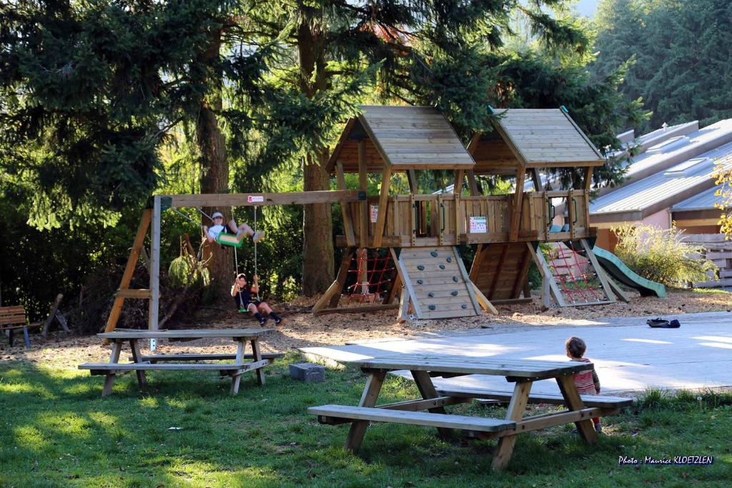 a playground with two picnic tables and a play structure at Domaine du Hirtz, Restaurant &amp; Spa in Wattwiller