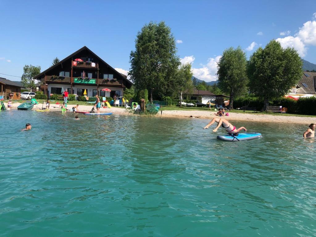 a group of people swimming in the water at Haus Kleinbichler in Faak am See
