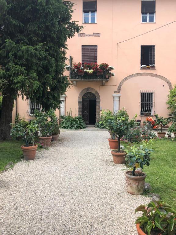 a building with a bunch of potted plants in front of it at Il Giardino in Lucca