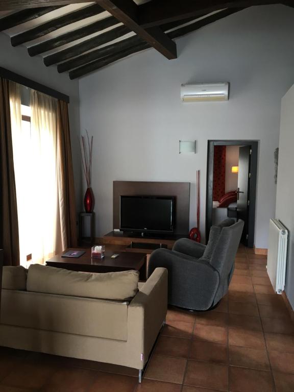 een woonkamer met een bank en stoelen en een televisie bij Apartamentos Jardines de Lorca in Lorca