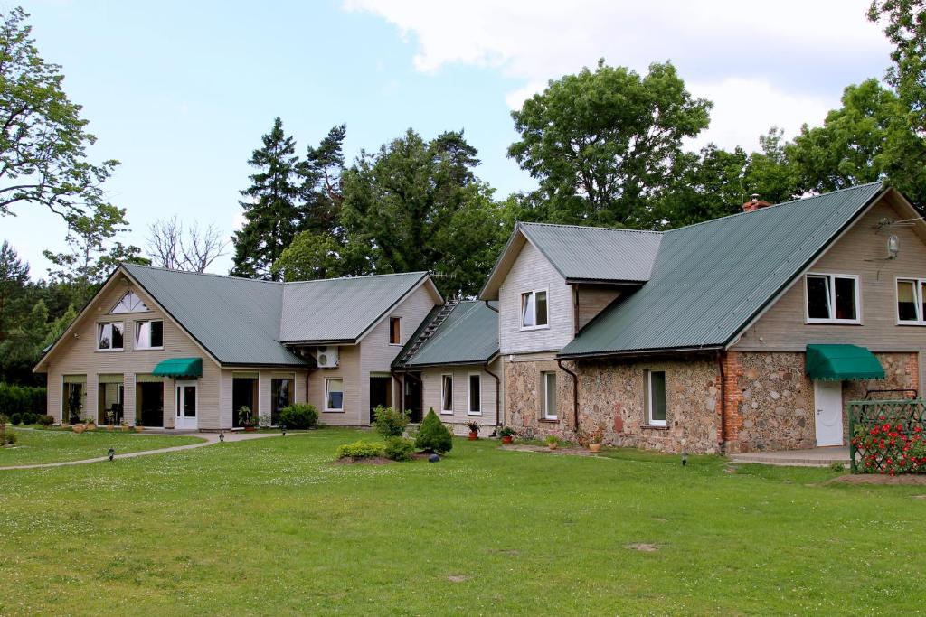 une rangée de maisons avec des toits verts dans l'établissement Imantas nams, à Jūrkalne