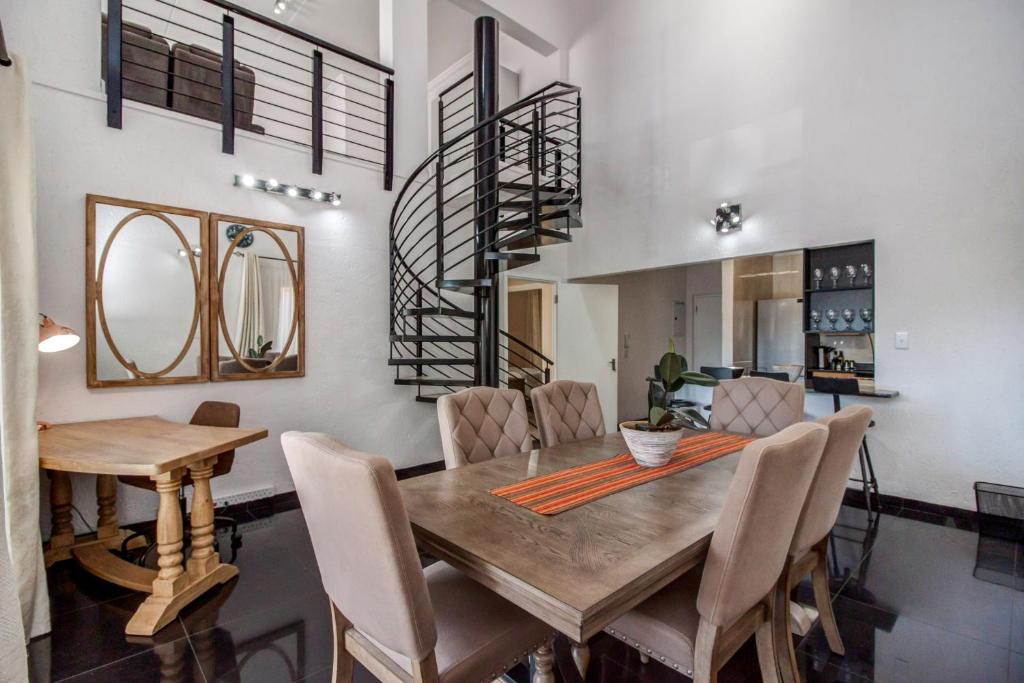 a dining room with a wooden table and chairs at Upmarket Sandton apartment in Johannesburg