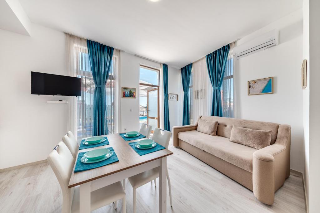 een woonkamer met een tafel en een bank bij Balchik Amazing Sea Apartments in Balchik
