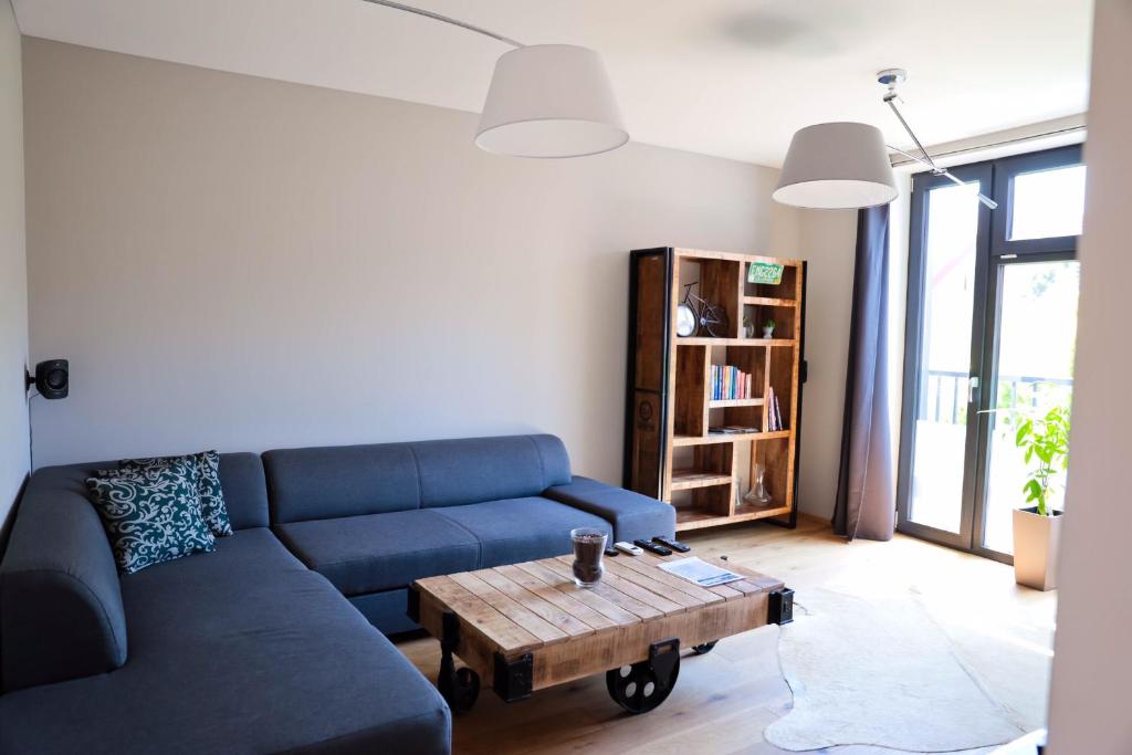 een woonkamer met een blauwe bank en een salontafel bij AH Corner House in Košice