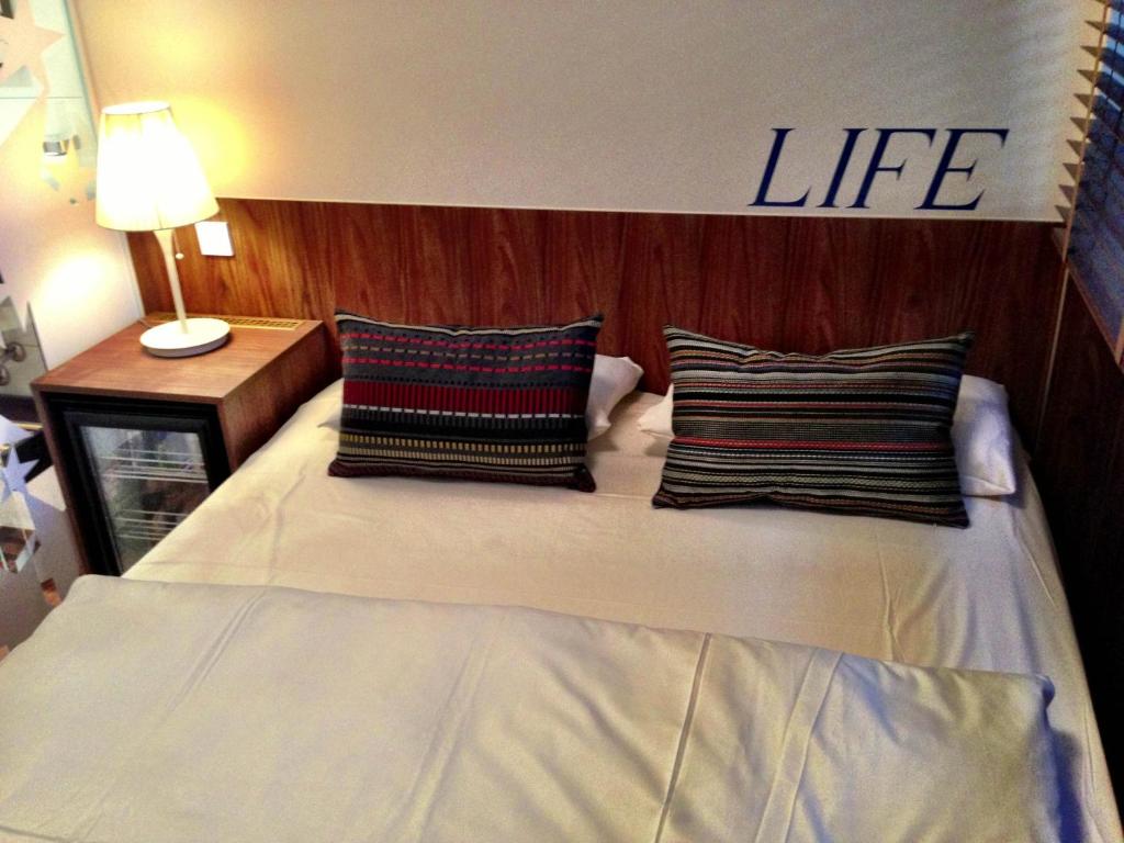 una cama con dos almohadas y un signo de vida en ella en Hotel Europa Life en Frankfurt
