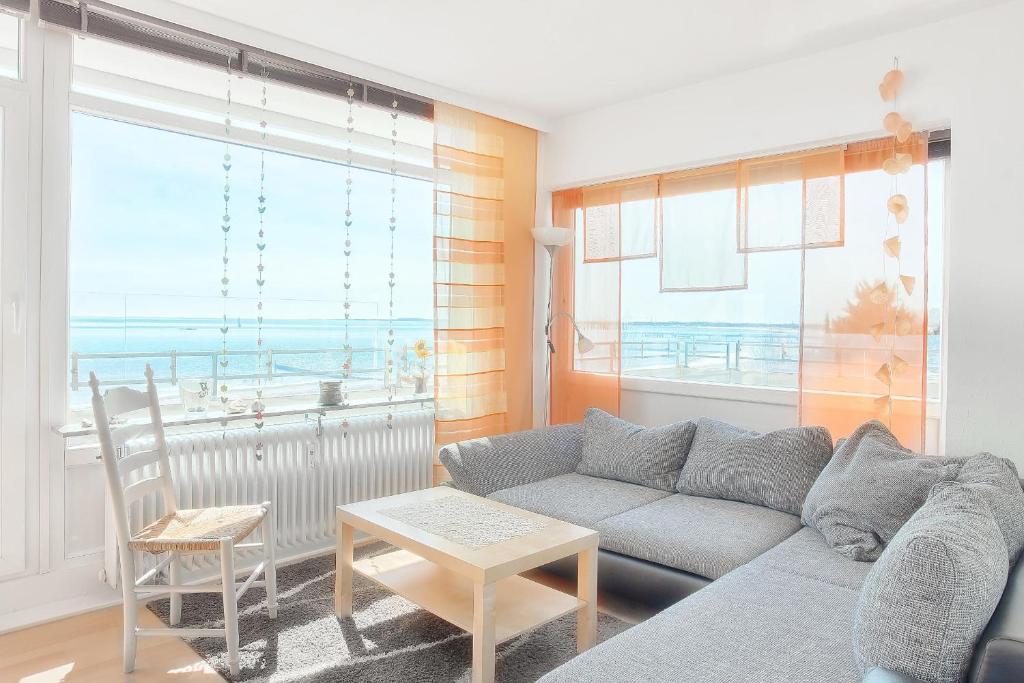 a living room with a couch and a view of the ocean at Vier Jahreszeiten 4-34 in Großenbrode