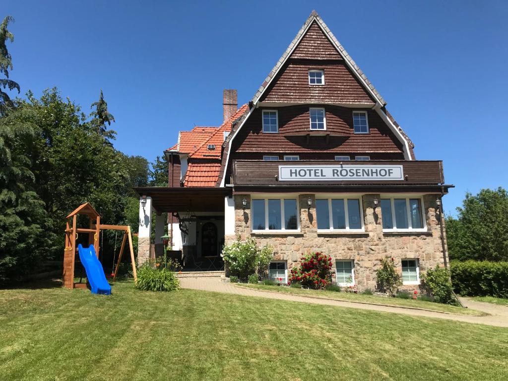 ein Haus mit einem Spielplatz davor in der Unterkunft Hotel Rosenhof Braunlage in Braunlage