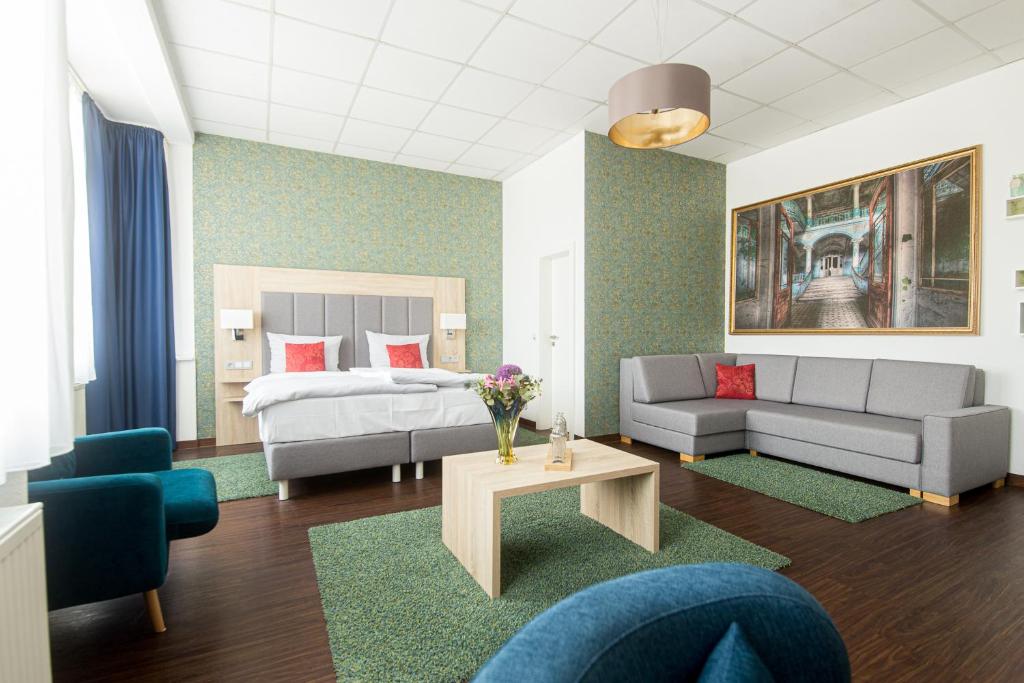 a living room with a bed and a couch at Pallas Hotel in Darmstadt