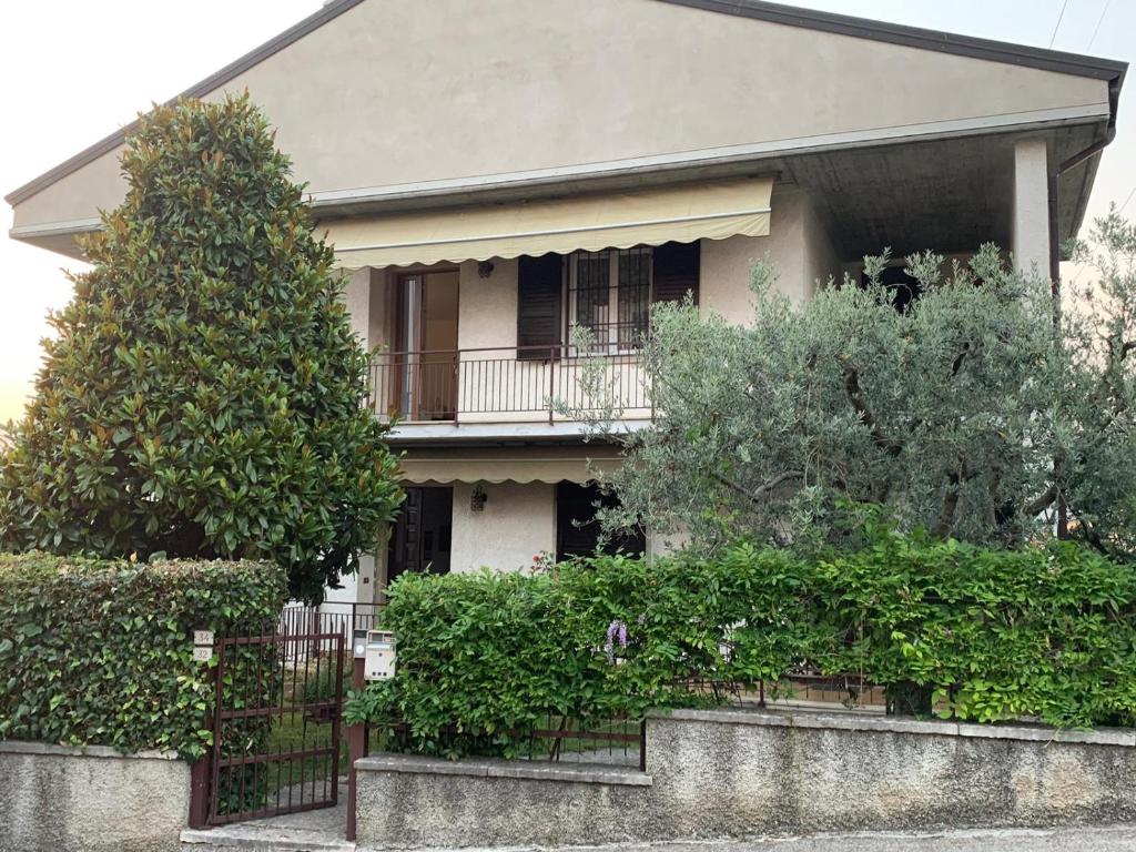 ein Haus mit einem Balkon und Büschen davor in der Unterkunft Casa Magnolia in Pastrengo