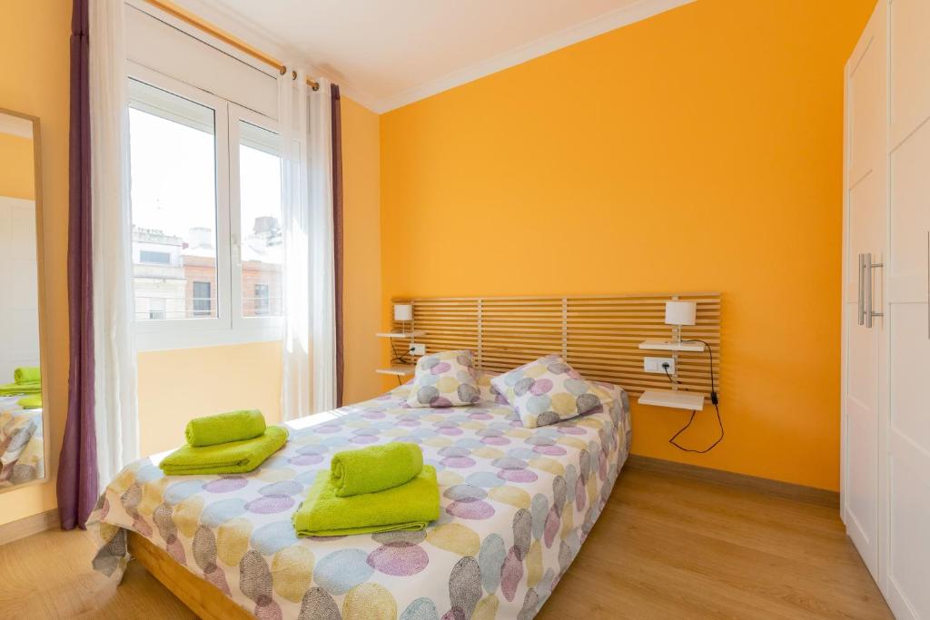 a bedroom with a bed with green towels on it at Lodging Apartments Guell & Gracia in Barcelona