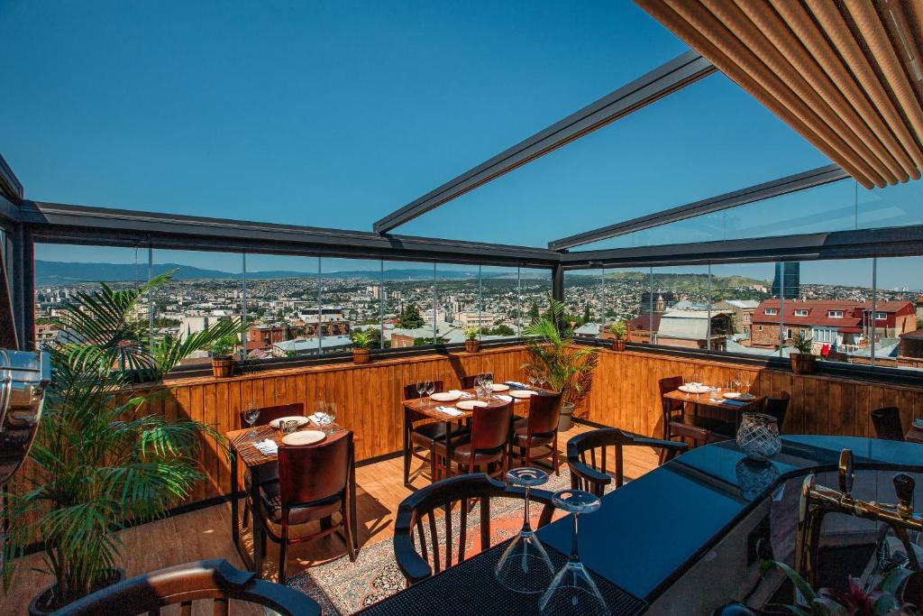 a restaurant with tables and chairs on a balcony at Urban Boutique Hotel in Tbilisi City