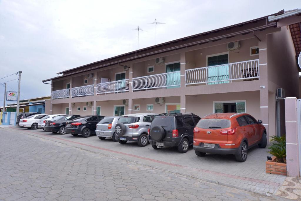 a row of cars parked in front of a building at Pousada Recanto das Cores in Penha
