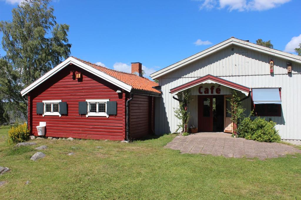 uma casa vermelha e branca com garagem em Café Björnen em Västerås