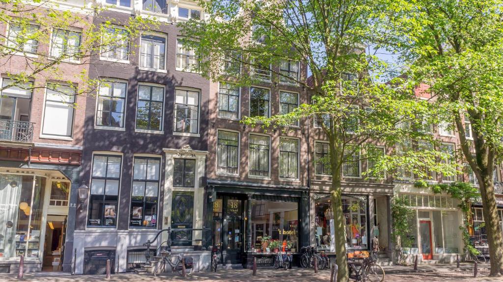 un edificio en una calle de Amsterdam con árboles en 't Hotel, en Ámsterdam