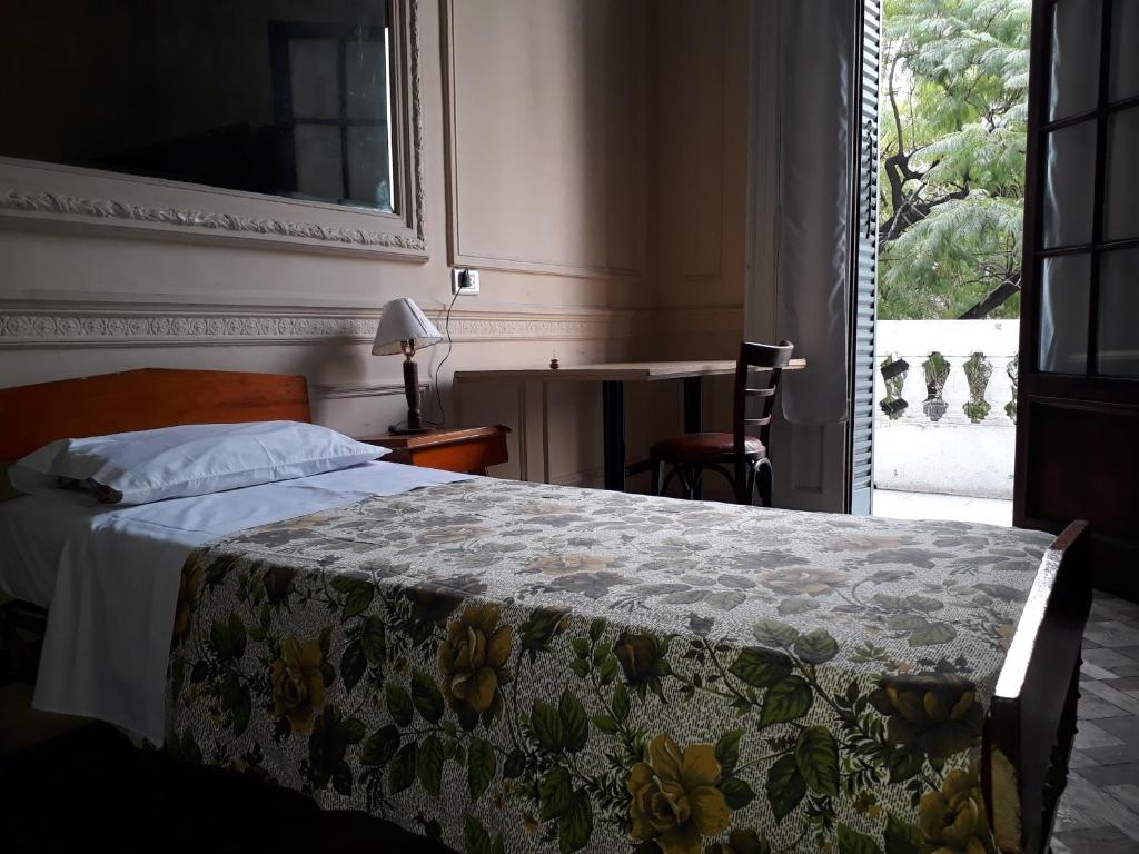 um quarto com uma cama e uma janela com uma secretária em Hotel El Pibe em Buenos Aires