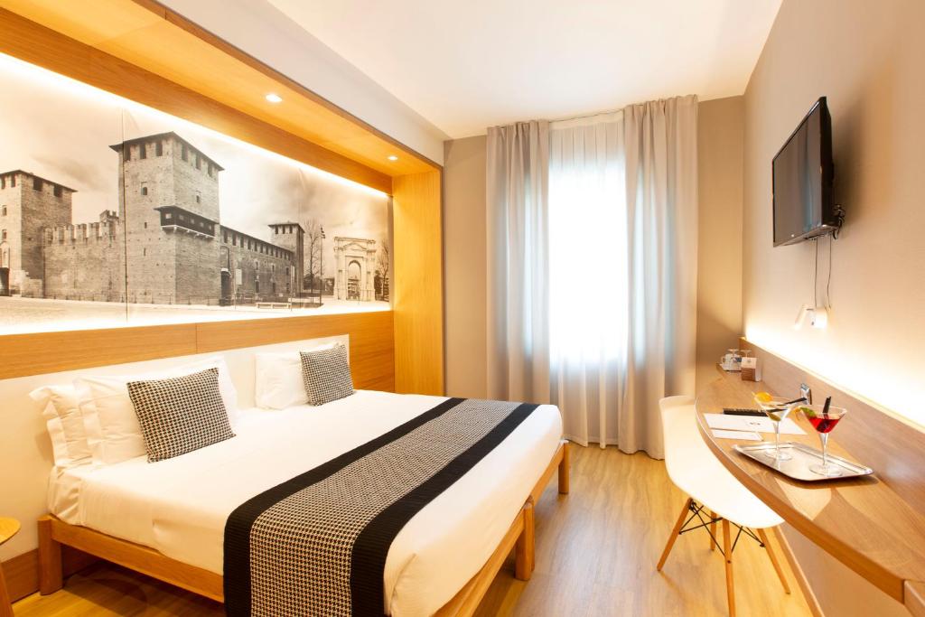 una camera d'albergo con letto e scrivania di Cavallo Hotel Verona Est a Verona