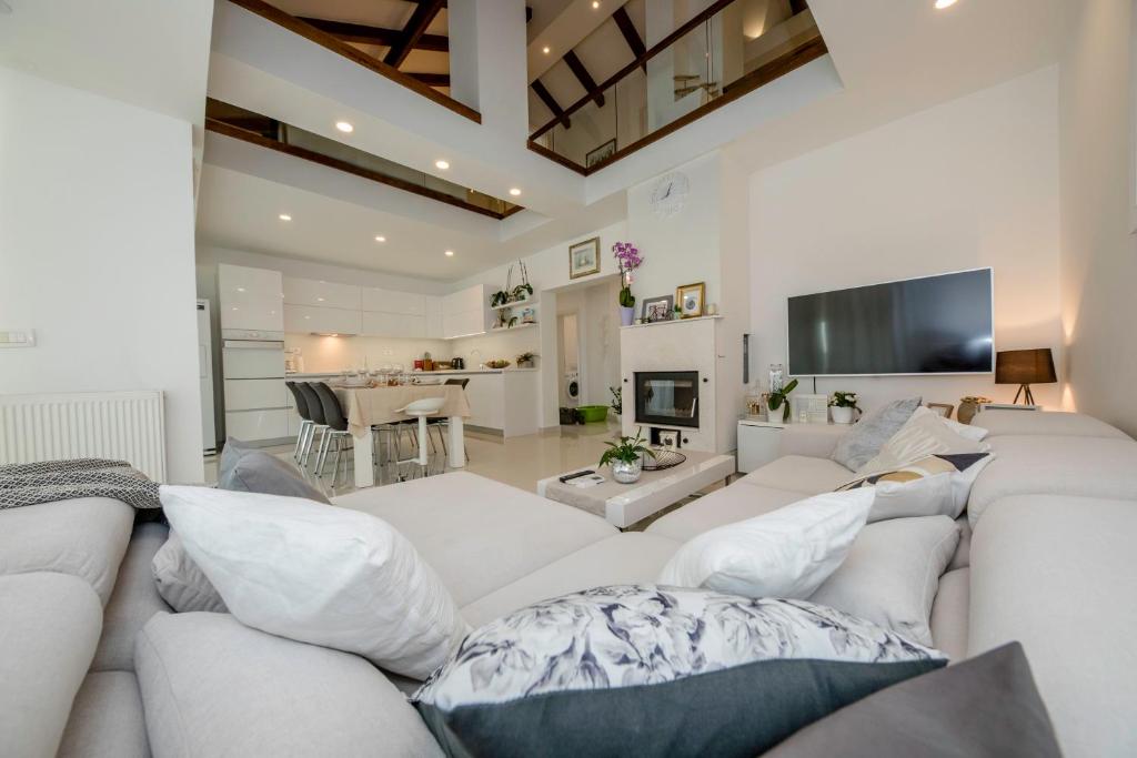 a living room with a white couch and a tv at Villa Bella in Banjol