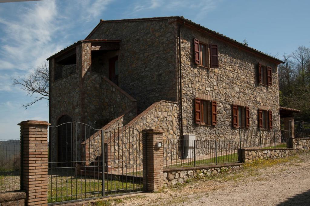 un vecchio edificio in pietra con una recinzione di fronte di Le Querce a Torre Alfina