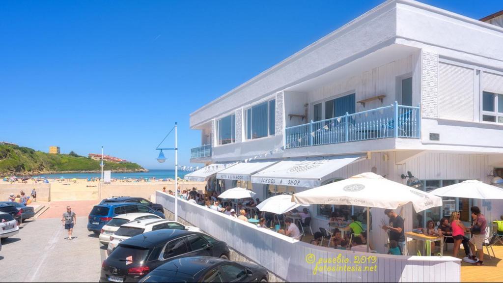 un restaurante en la playa junto a un edificio en La Surfería Suances, en Suances