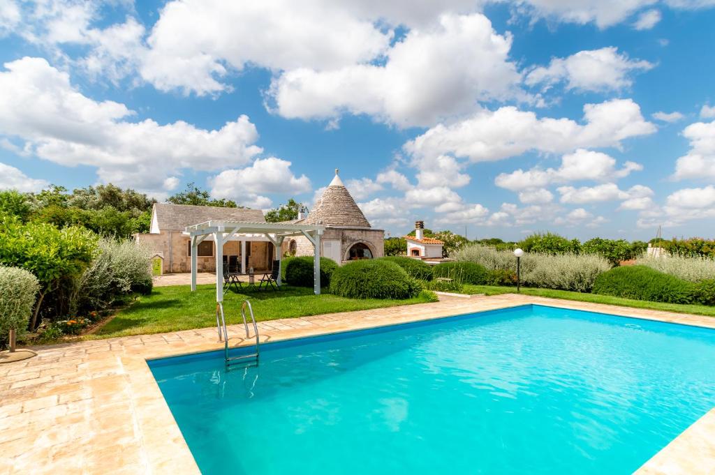 ein Haus mit einem Pool und einem Pavillon in der Unterkunft WePuglia - Trullo Rampone in Martina Franca