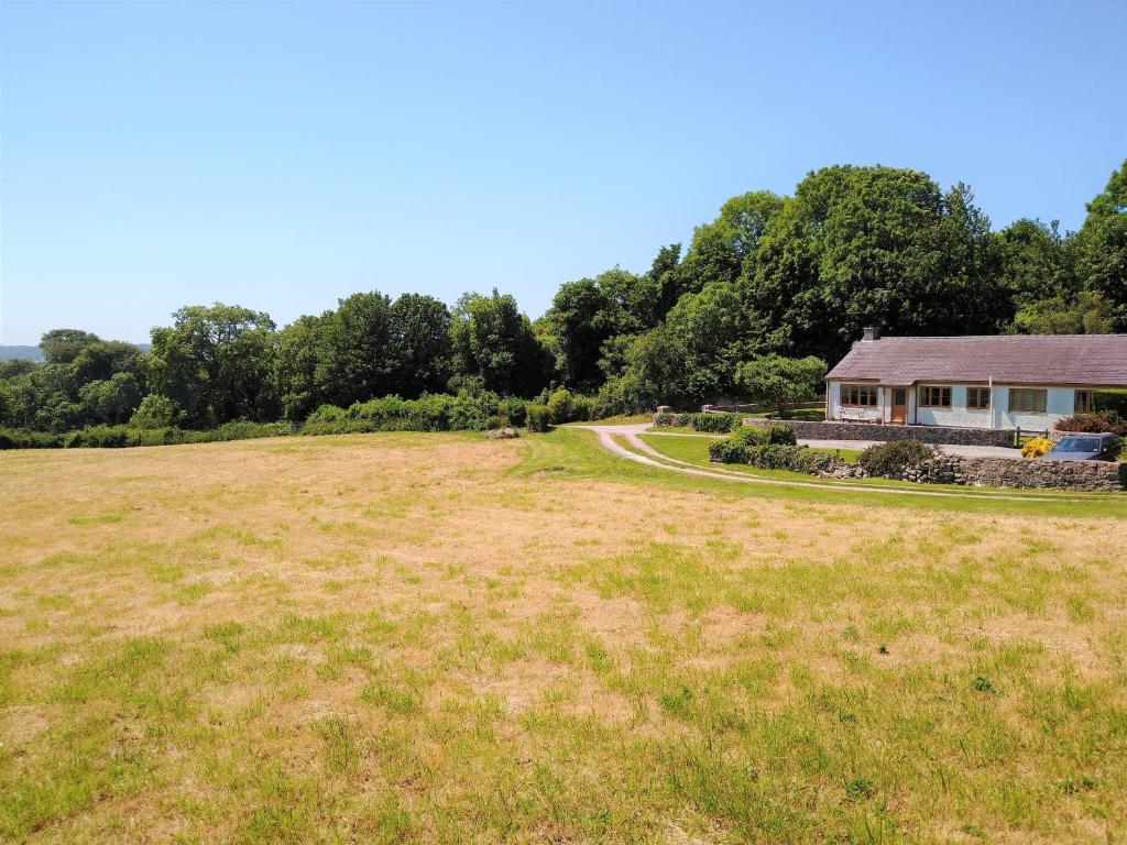 un campo abierto con una casa en el fondo en Llinos Cottage, en Beaumaris