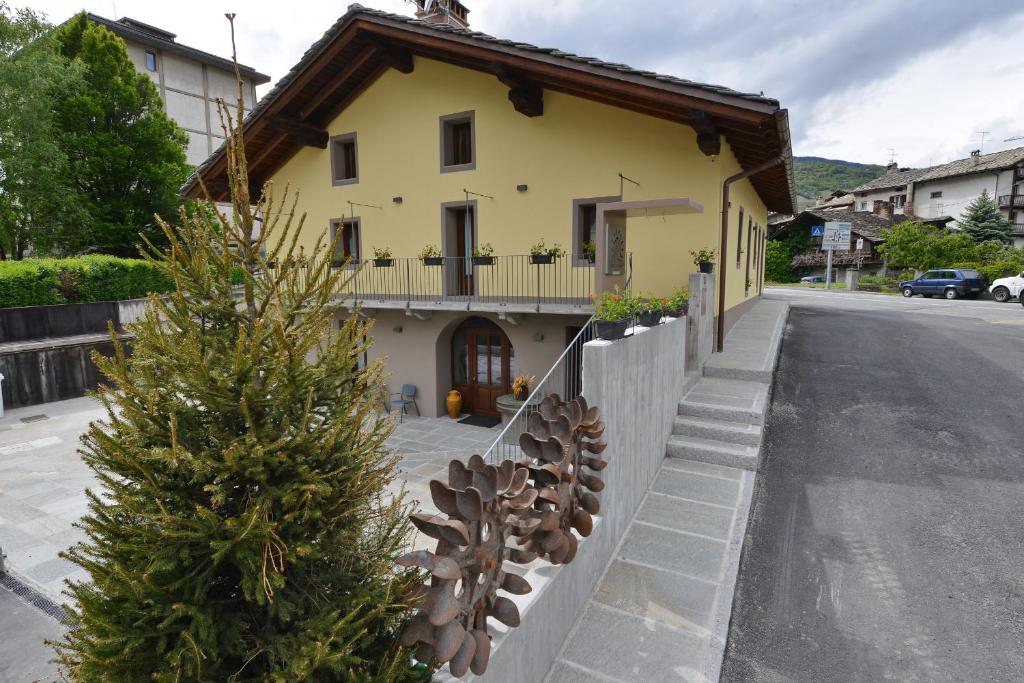 une maison avec un arbre de Noël sur le côté de la rue dans l'établissement Vecchio Mulino Guest House, à Aoste