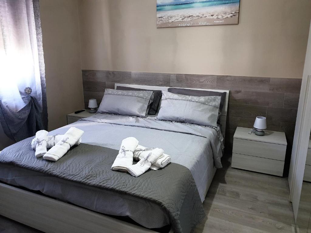 Un dormitorio con una cama con toallas blancas. en Suite Bice In Villaggio Seleno en Ovile la Marinella