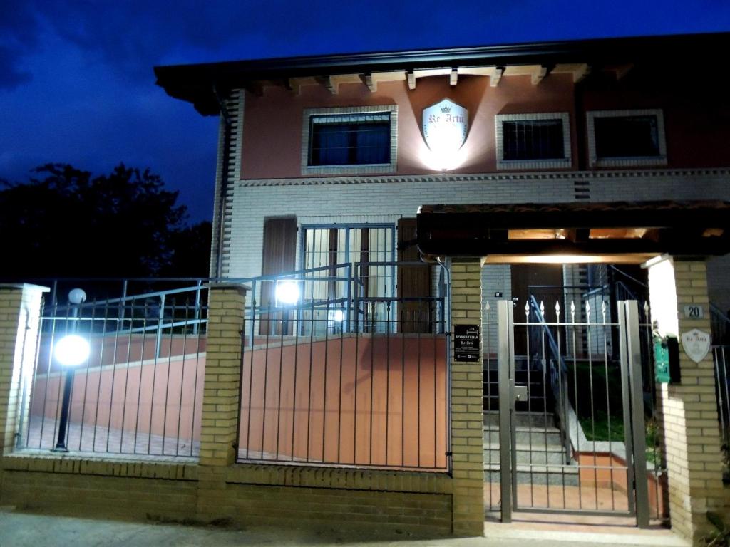 uma casa com um portão à frente à noite em foresteria re artù em Albairate