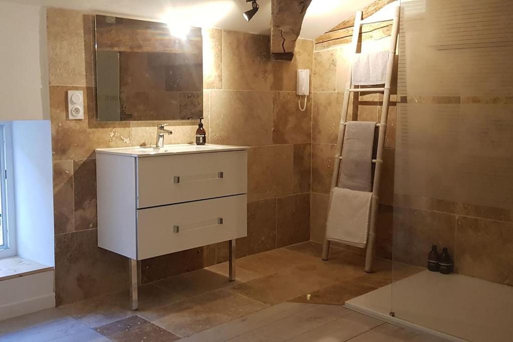 ein Badezimmer mit einem Waschbecken, einem Spiegel und einer Leiter in der Unterkunft La Cabane in Penne-dʼAgenais