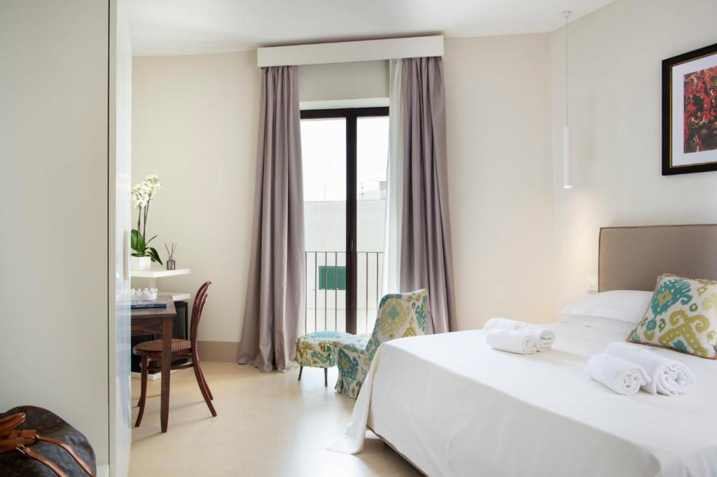 a hotel room with a bed and a table and chairs at I Bastioni San Domenico - Boutique Hotel in Gallipoli