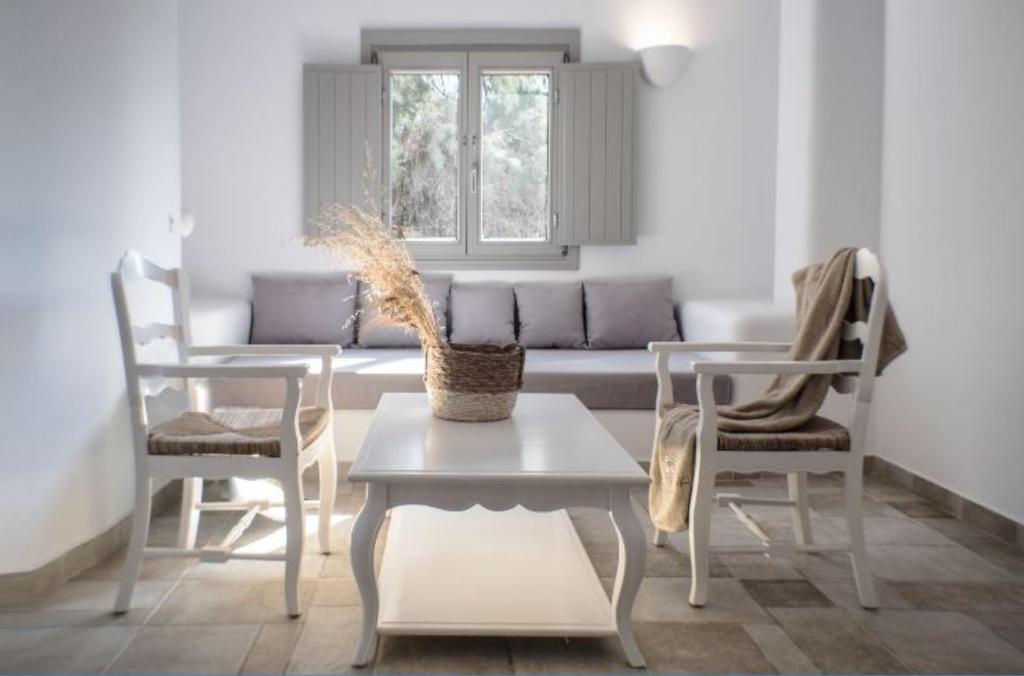 a living room with a table and chairs and a couch at Helios Beach Hotel in Perissa