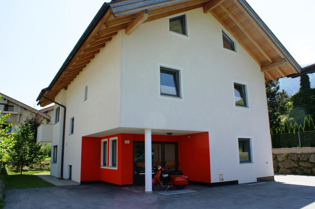 a white and red house with a red garage at Appartements Markus in Ried im Zillertal