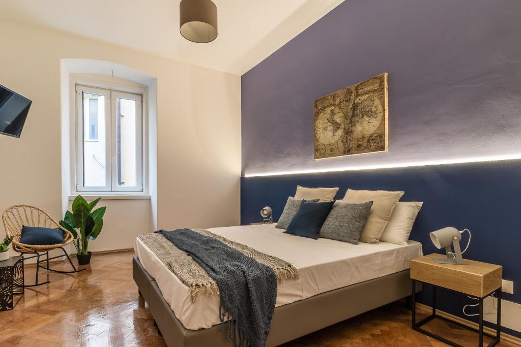 um quarto com uma cama com uma parede azul em Pregiata camera con bagno privato - Blu di Prussia em Trieste