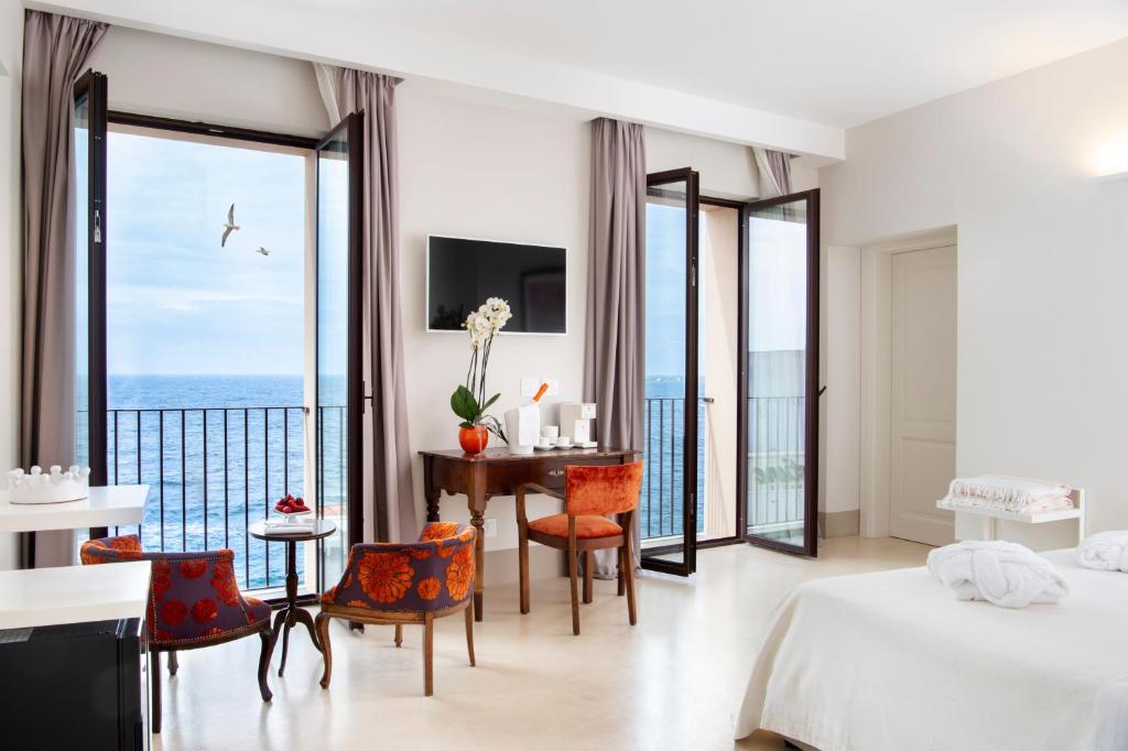 a bedroom with a bed and a table and chairs at I Bastioni San Domenico - Boutique Hotel in Gallipoli
