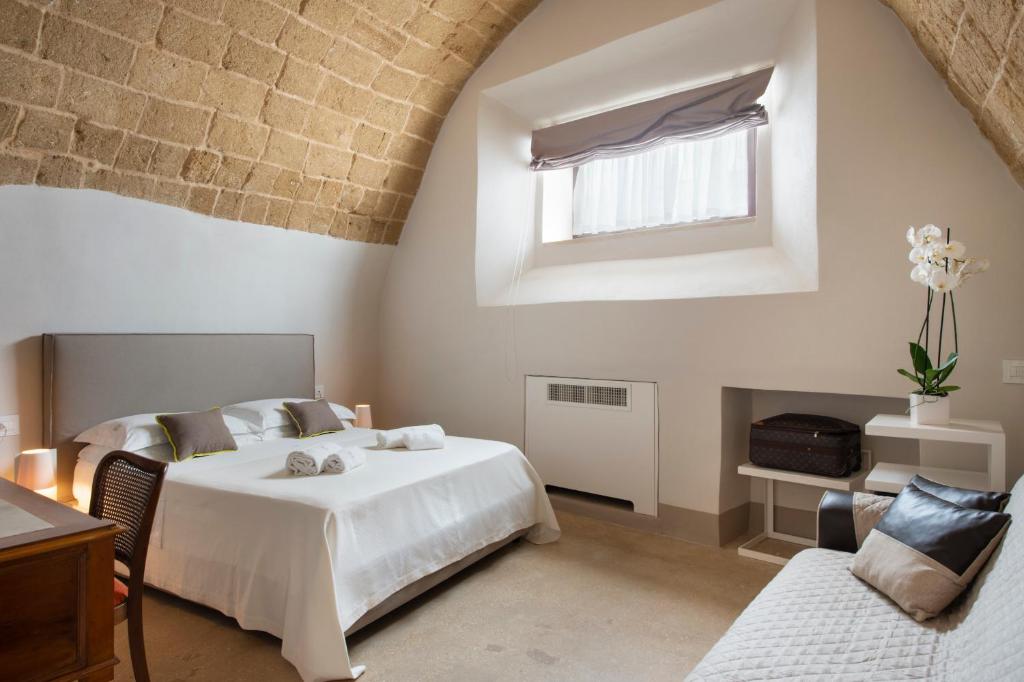 a bedroom with a large white bed and a window at I Bastioni San Domenico - Boutique Hotel in Gallipoli