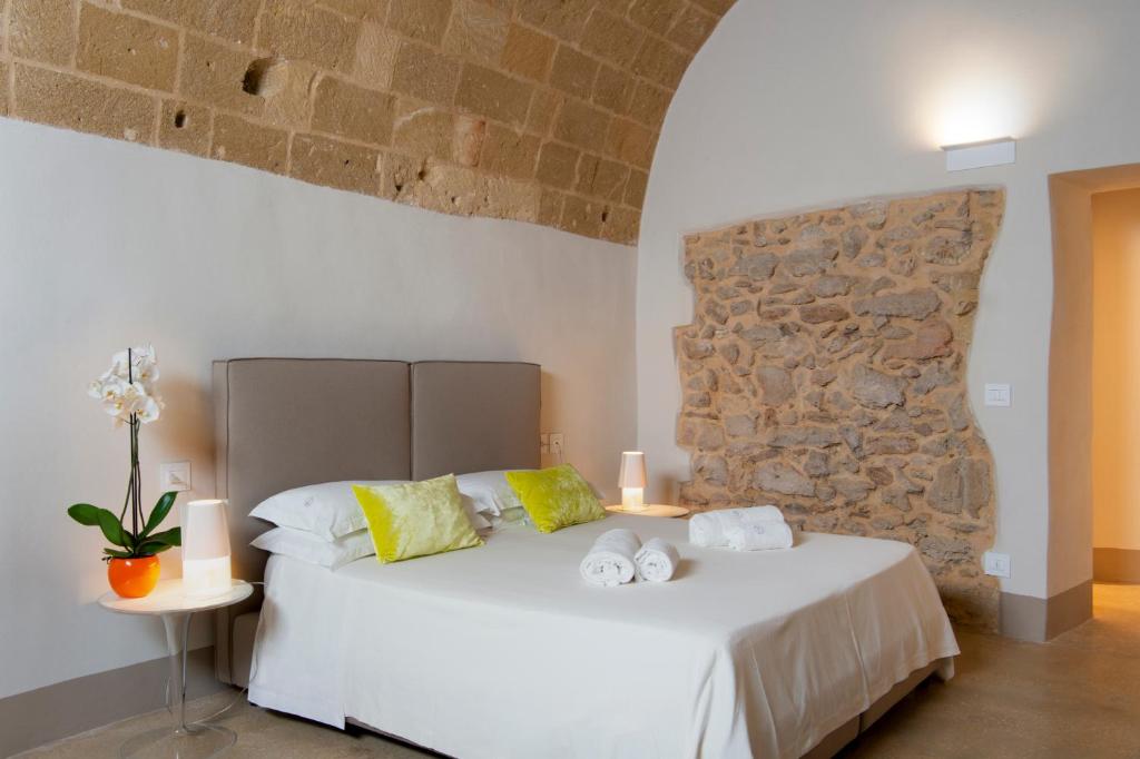 a bedroom with a white bed with towels on it at I Bastioni San Domenico - Boutique Hotel in Gallipoli