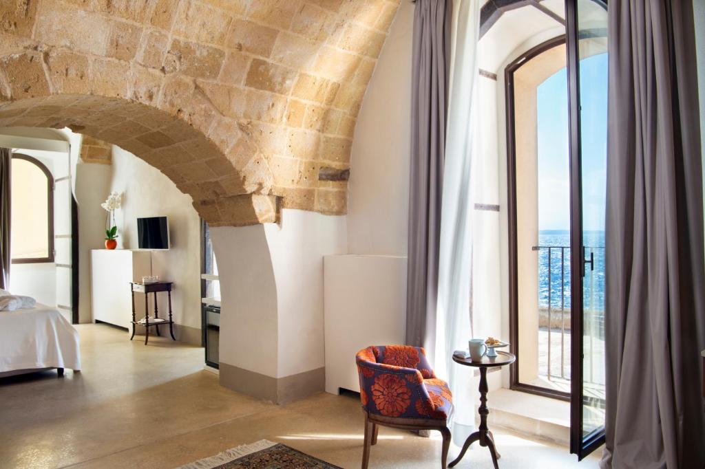 a room with a bed and a large window at I Bastioni San Domenico - Boutique Hotel in Gallipoli