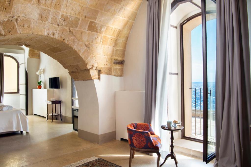a living room with a stone wall and a large window at I Bastioni San Domenico in Gallipoli