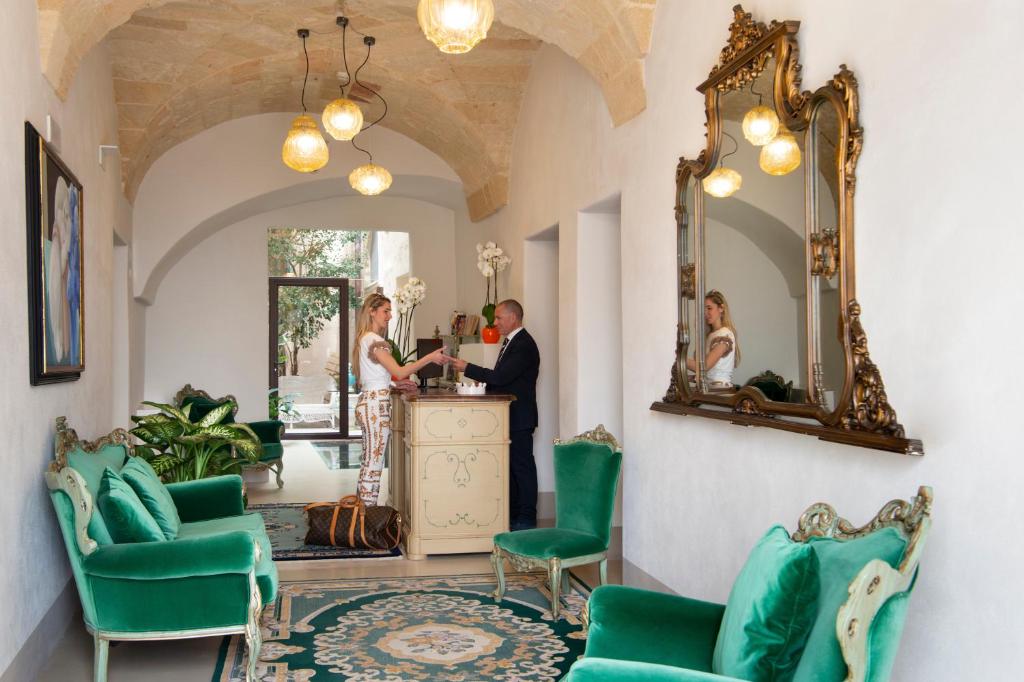 a man and a woman standing at a counter in a room at I Bastioni San Domenico - Boutique Hotel in Gallipoli
