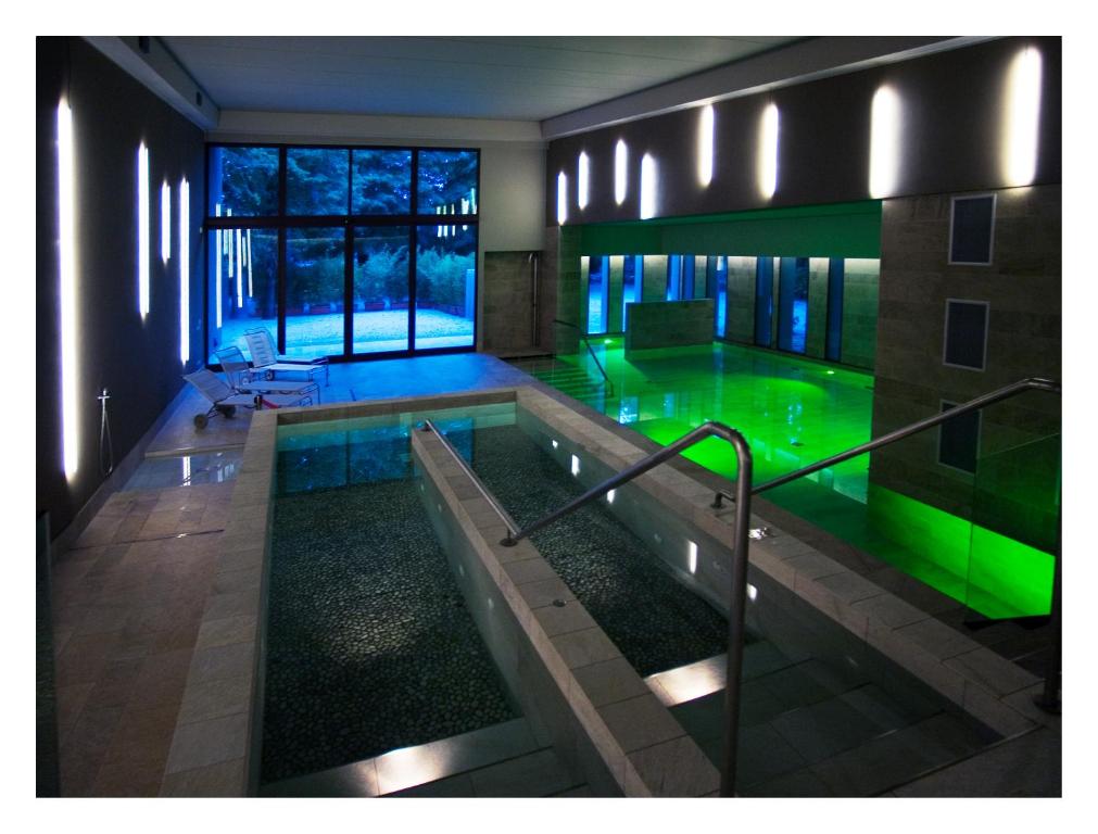 a swimming pool in a building with green lighting at Residence Alleterme in Rivanazzano