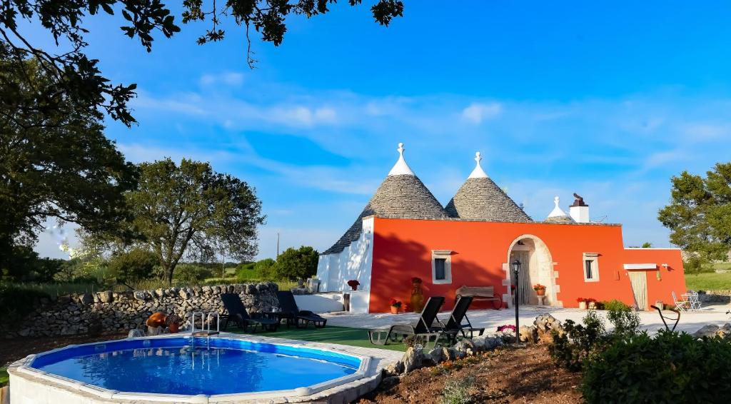 una casa naranja con una piscina frente a ella en Trullo Barratta en Martina Franca